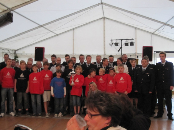 Gruppenbild der Ortsfeuerwehr Bresinchen zu Ihrem 90 Jährigen Jubiläum sowie dem 10-jährigen Bestehen der Jugendfeuerwehr im Ort mit der BB-RADIO Moderatorin Clara Himmel