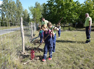 Auf dem Gelände des Ehrenhains wird heruntergefallenes Laub zusammengeharkt und anschließend entsorgt