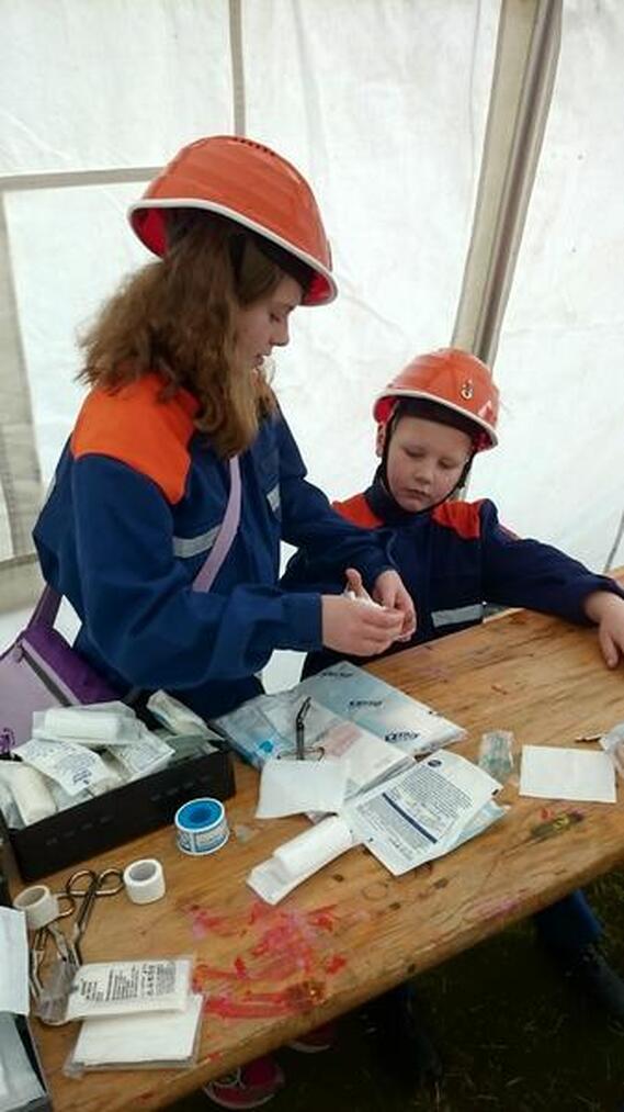 Angelina legt bei Leon einen Handverband an