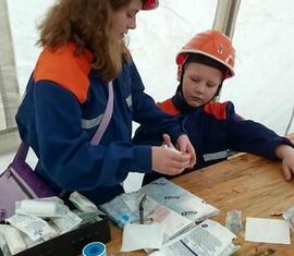 Angelina legt bei Leon einen Handverband an