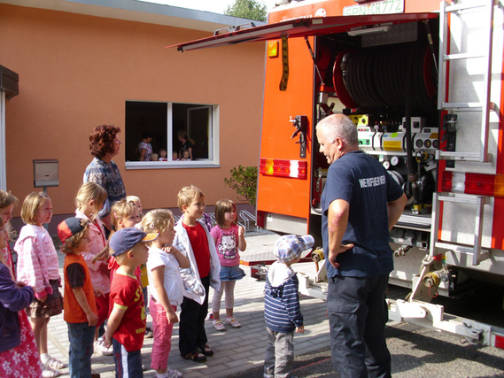 Herr Grunewald, mit den Kindern der Kita und des Hortes am Tanklöschfahrzeug.