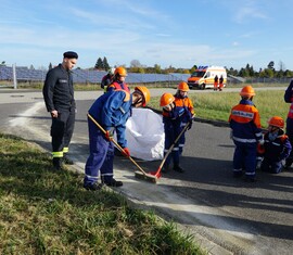 Die Ölspur wird mit Bindemittel abgestreut und anschließend aufgenommen