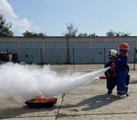 Löschen eines Feuers mit einem Pulverhandfeuerlöscher